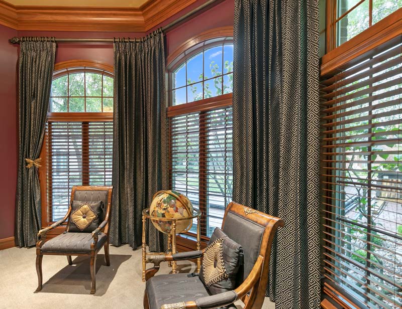 A speakeasy sitting room with wood blinds and french pleat draperies